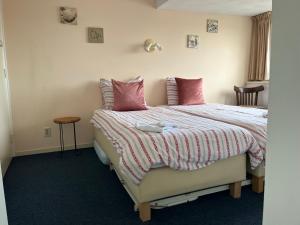 een slaapkamer met een bed met roze kussens bij Hotel Noordzee in Zandvoort