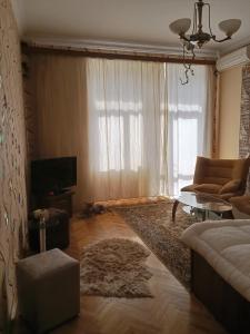 a living room with a couch and a tv at Квартира в престижном районе Баку in Baku