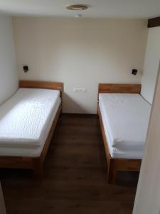 Duas camas num quarto com paredes brancas e pisos em madeira em Monteurunterkunft Drescher em Bad Arolsen