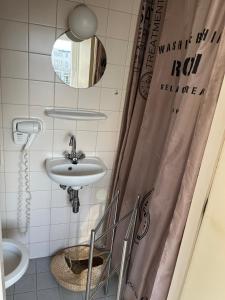 een badkamer met een wastafel en een spiegel bij Hotel Noordzee in Zandvoort