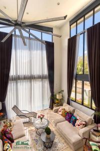 ein Wohnzimmer mit einem Sofa und großen Fenstern in der Unterkunft Adora's Place - Signature Room in Coron