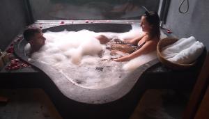 a man and a woman sitting in a bath tub at Palm View Villa in Hoi An