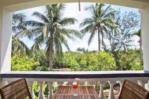 a table on a balcony with a view of palm trees at Palm View Villa in Hoi An