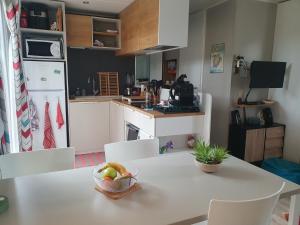 eine Küche mit einem Tisch und einer Obstschale darauf in der Unterkunft Mobilhome Grand confort 6 à 8 personnes in Sainte-Marie-de-Ré