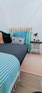 a room with a blue bed with pillows on it at Maison de vacances 2 chambres plages lac à 600m proche Dune du Pilat Océan dans propriété privée in Sanguinet