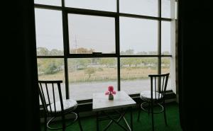 stół i dwa krzesła przed oknem w obiekcie Danny Luxe Apartments w mieście Islamabad