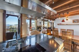 a kitchen with a counter top and a table at 200m ski slopes - Chalet Manora - Courchevel La Tania in Courchevel
