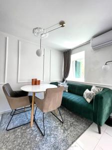 - un salon avec un canapé vert et une table dans l'établissement Apartments Providenca, à Split