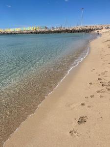 una playa con huellas en la arena y el agua en Casa vacanze Brezza di mare, en Campomarino