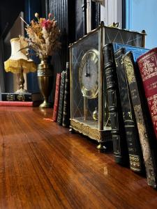 un groupe de livres et une horloge sur une table dans l'établissement Hôtel Abalone - Centre Gare, à Nîmes