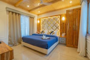 Un dormitorio con una cama azul y una ventana en PerfectStayz Paradise, en Mussoorie