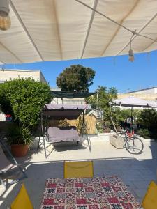 un patio con mesa, sillas y alfombra en Casa vacanze Brezza di mare, en Campomarino