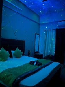 a bedroom with a bed with blue lights on it at Bella Dreamy near expo mart greater Noida in Greater Noida