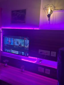a living room with purple lights on a wall at Bella Dreamy near expo mart greater Noida in Greater Noida