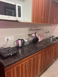 a kitchen counter with a stove and a microwave at Bella Dreamy near expo mart greater Noida in Greater Noida