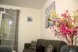 una sala de estar con sofá y un jarrón de flores en Apartment Danijela, en Zadar