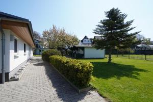 a house with a tree next to a yard at Pension Middel in Binz