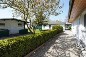 a sidewalk next to a house with a hedge at Pension Middel in Binz