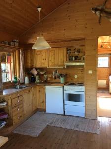 a kitchen with white appliances in a wooden cabin at Haukeli Mountain Cabin in Vågsli