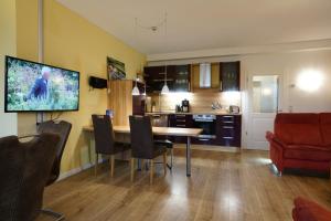 a living room with a dining room table and a kitchen at FEWO Seekiste Seeufervilla in Flessenow