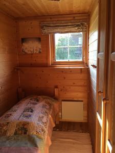 a bed in a log cabin with a window at Haukeli Mountain Cabin in Vågsli