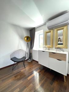 Cette chambre comprend un bureau, une chaise et des miroirs. dans l'établissement Apartments Providenca, à Split