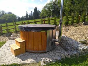 a large wooden tub in a yard with a fence at Chata na Zbojskej - Zbojská in Pohronská Polhora