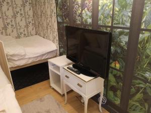 um pequeno quarto com uma televisão numa mesa com uma cama em Kopparstugans Bed & Breakfast em Falun