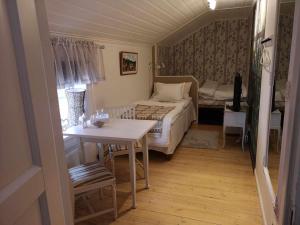 a bedroom with a bed and a table and a table and chairs at Kopparstugans Bed & Breakfast in Falun