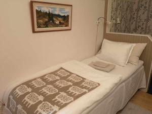 ファールンにあるKopparstugans Bed & Breakfastの小さなベッド(毛布付)が備わる客室です。