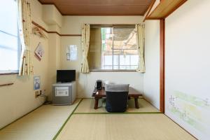 OYO Ryokan Hamanako no Yado Kosai - Vacation STAY 38804v في Kosai: غرفة صغيرة مع مكتب ونافذة
