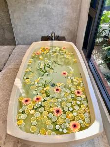 a bath tub filled with water with flowers in it at Flowering Villa in Xiaoliuqiu