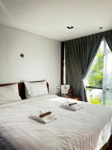 a bedroom with a large bed with two towels on it at 4 Simple Minimalistic Rooms at Sunset Lodge - Eco Valley Retreat 