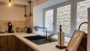 eine Küchentheke mit einem Waschbecken und einem Fenster in der Unterkunft Casa Do Oceano - Centre Ville - BY PRIMO C0NCIERGERIE in Tournus