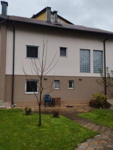 a building with a tree in a yard at Apartman Šljivo in Konjic