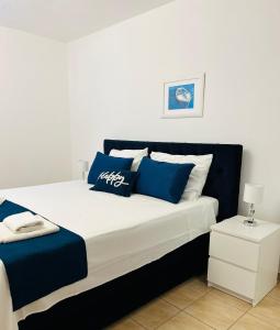 a bedroom with a large bed with blue and white pillows at Hvar beach vacation in Vrboska