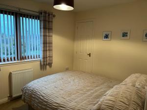 um quarto com uma cama e uma janela em The Old Mill Apartment, on NC500 em Brora
