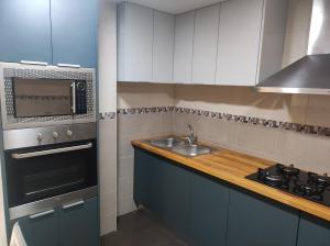 a kitchen with a sink and a microwave at Alojamiento El palmeral in Santa Pola