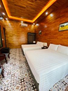2 camas en una habitación con paredes de madera en Tam Coc Galaxy Villa en Ninh Binh