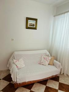 - un canapé blanc avec deux oreillers dans l'établissement Hvar beach vacation, à Vrboska
