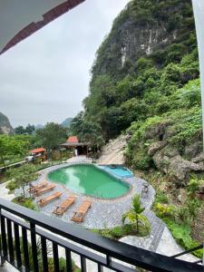 a view of a swimming pool with chairs and a mountain at Tam Coc Galaxy Villa in Ninh Binh