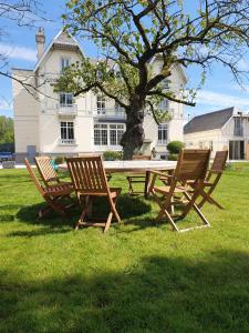 a picnic table and three chairs in front of a house at La Roseraie in Saint-Étienne-au-Mont