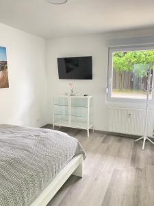 a bedroom with a bed and a tv and a window at Komfortable Wohnung in bester Lage in Herne