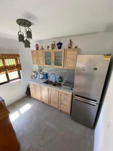 a kitchen with a stainless steel refrigerator and wooden cabinets at Pedi’s house in Aspropótamos +23 photos