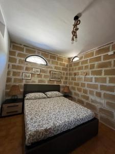 sypialnia z łóżkiem i ceglaną ścianą w obiekcie Villa Ninni w mieście Tarent
