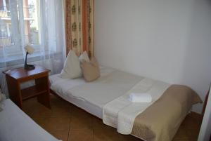 pokój hotelowy z łóżkiem i stolikiem nocnym z łóżkiem o wymiarach 6 x 6 x 6 x w obiekcie Natural Mielno w mieście Mielno
