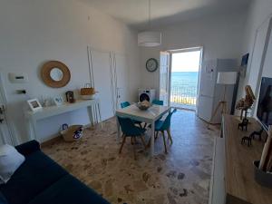 a living room with a blue couch and a table and chairs at Le due conchiglie in Carini