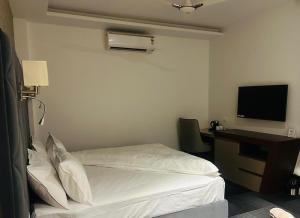 a hotel room with a bed and a desk with a television at Eminence The Corbett in Jhirna