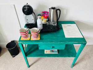 a green table with cups on top of it at Treheveras Guest House in Newquay