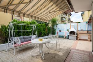 un patio con mesa, silla y sofá en Jolly private room with bathroom, en Venecia